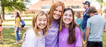 three girls linking arms at fall admissions visit event